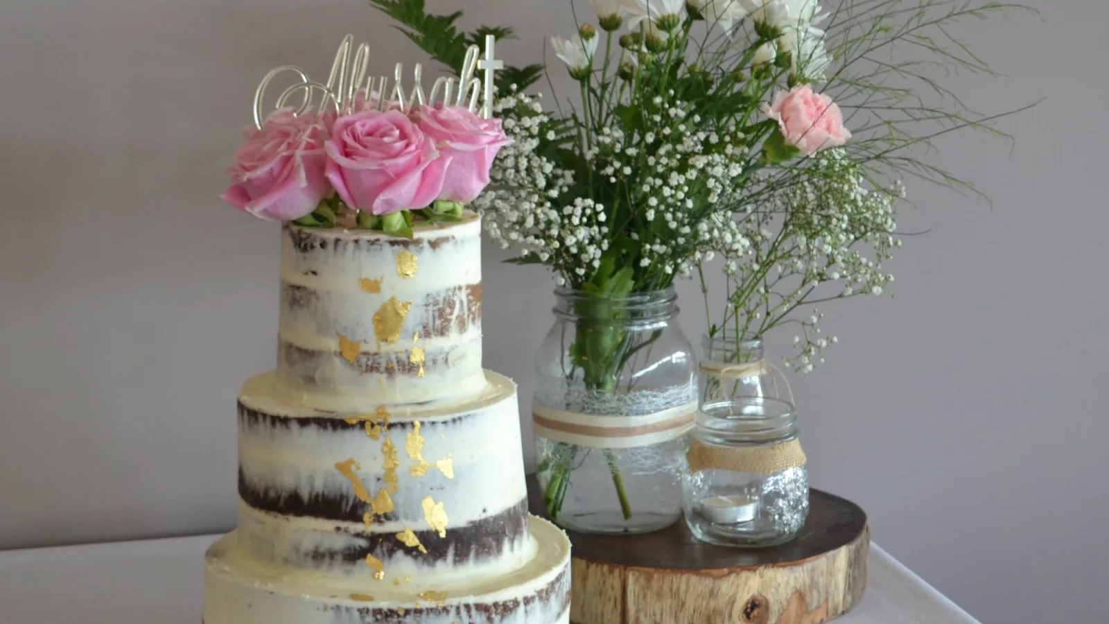 Three tier wedding cake with flowers in the background