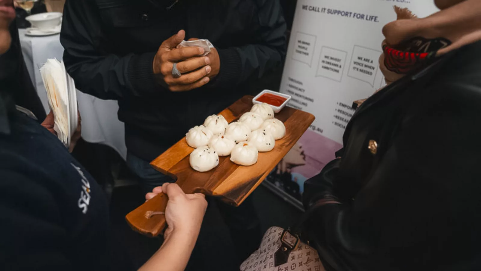 Waiter offers dumplings to function guests