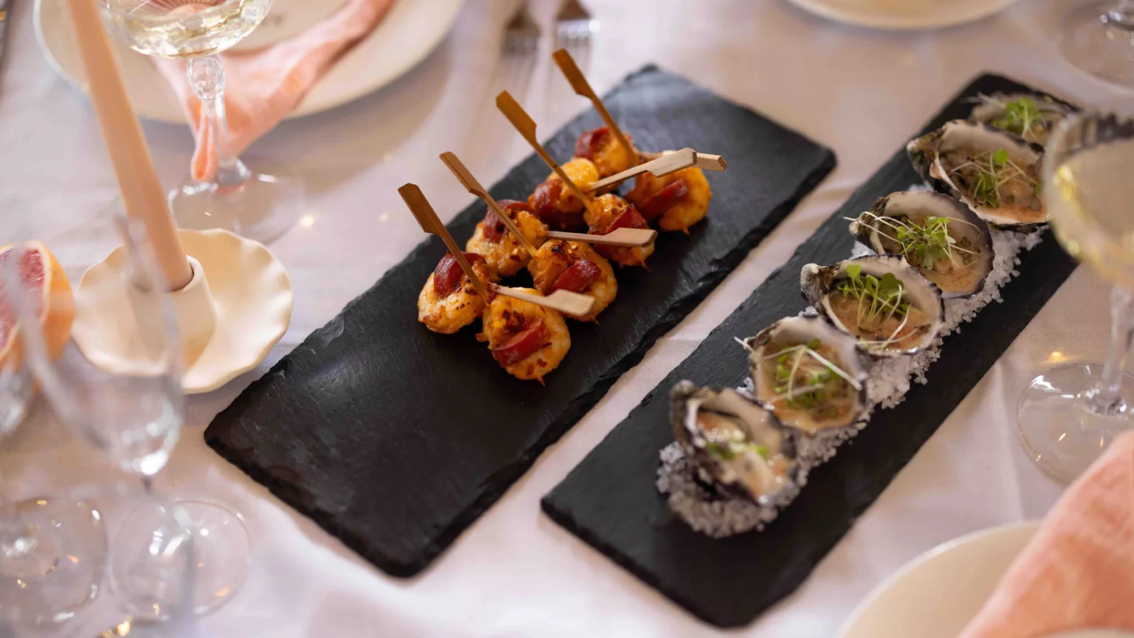 Canapé food on the table with champagne and candles
