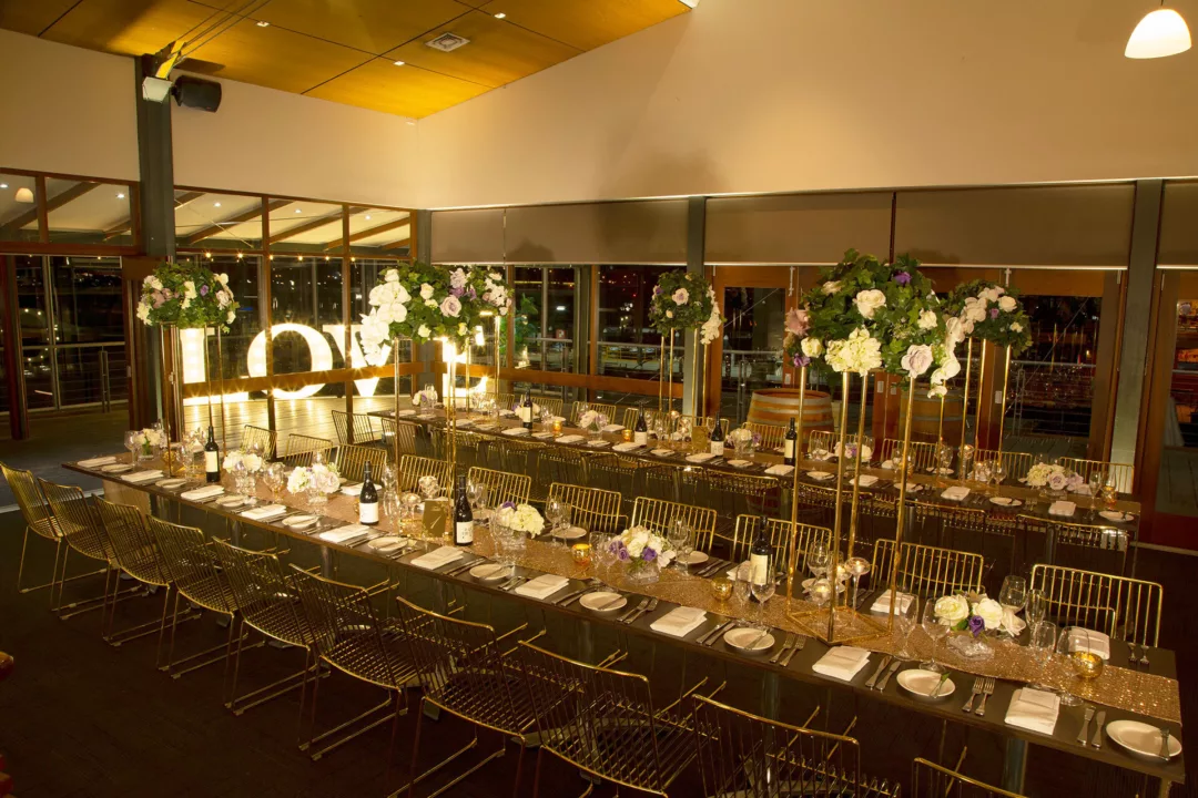 Function space set for a wedding reception with long tables decorated with flowers.