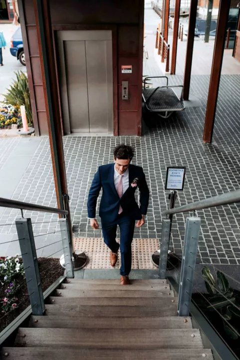 Groom walks up steps to the wedding venue