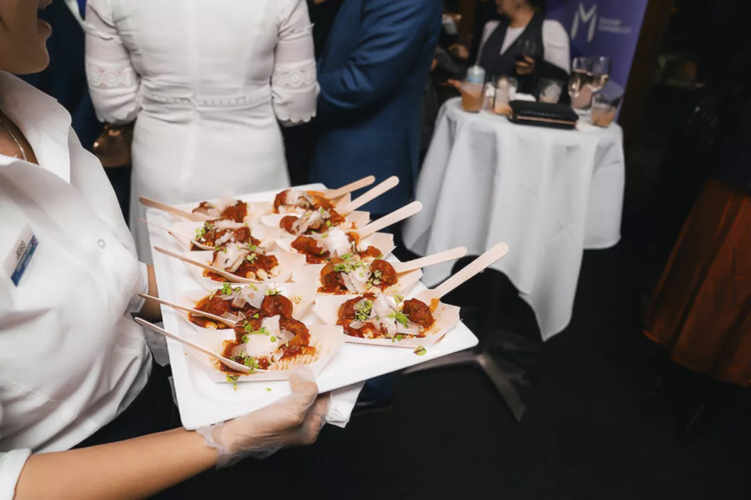 A waiter carries plate of canapes