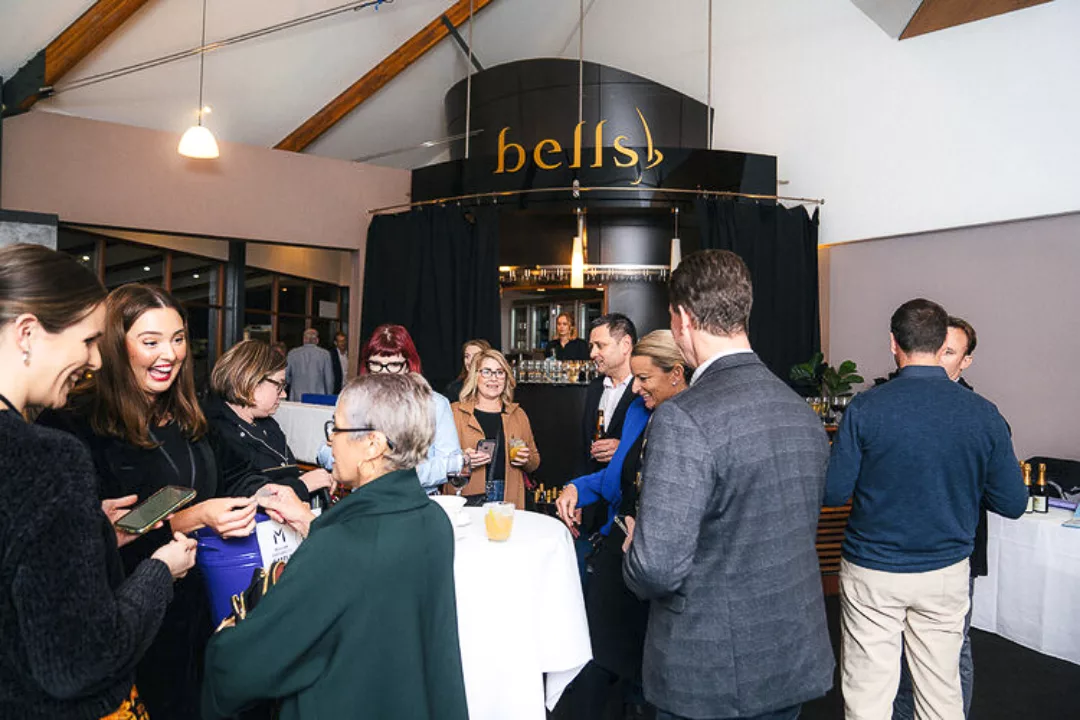 A group of adults mingle at a networking event at bells functions