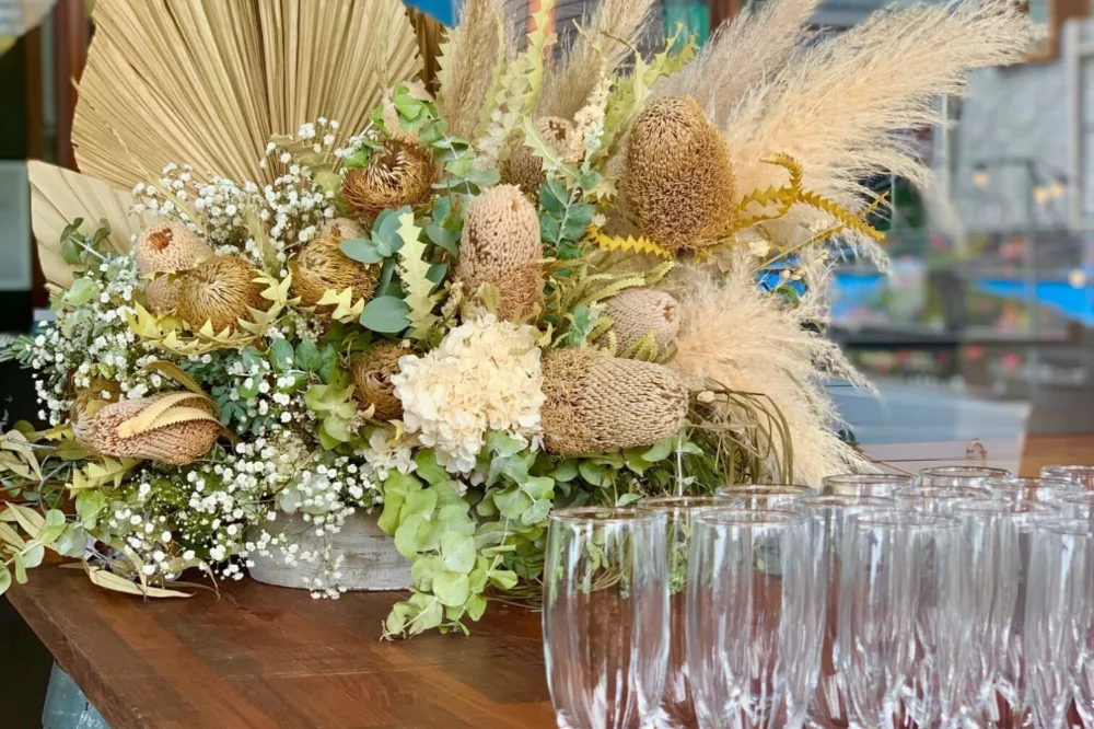Champagne flutes with a floral arrangement in the background