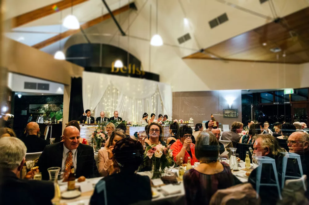 Wedding venue full of guests seated at tables for meals