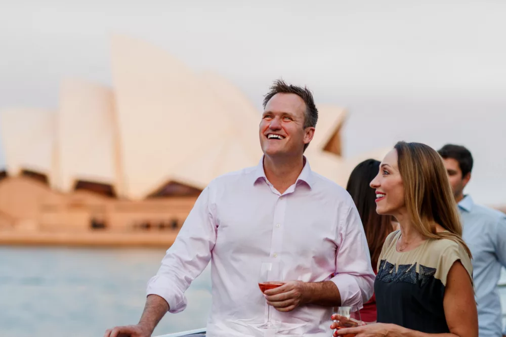 Senior couple enjoying harbour views premium sightseeing with Opera House in the background