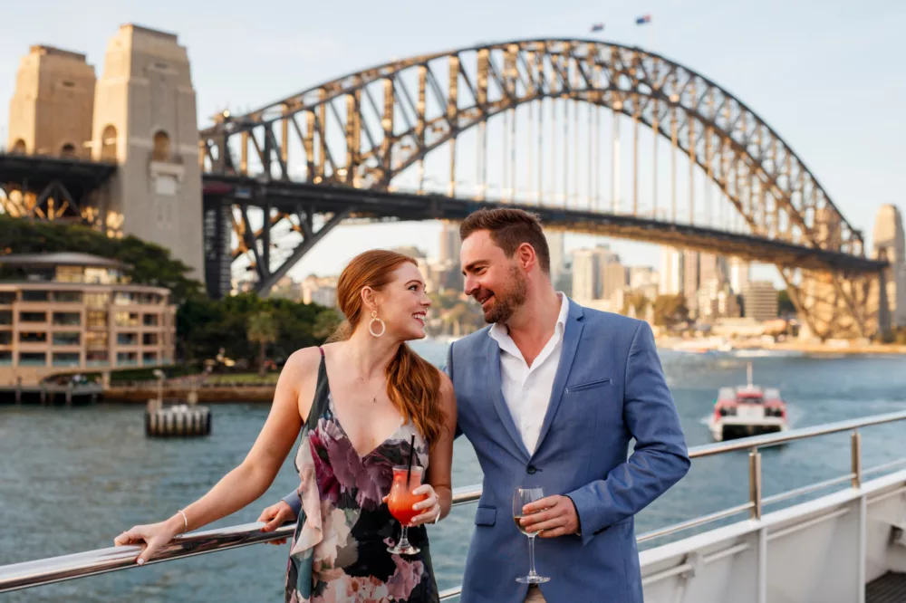 Premium couple having cocktail and wine outdoor with Harbour Bridge on the background
