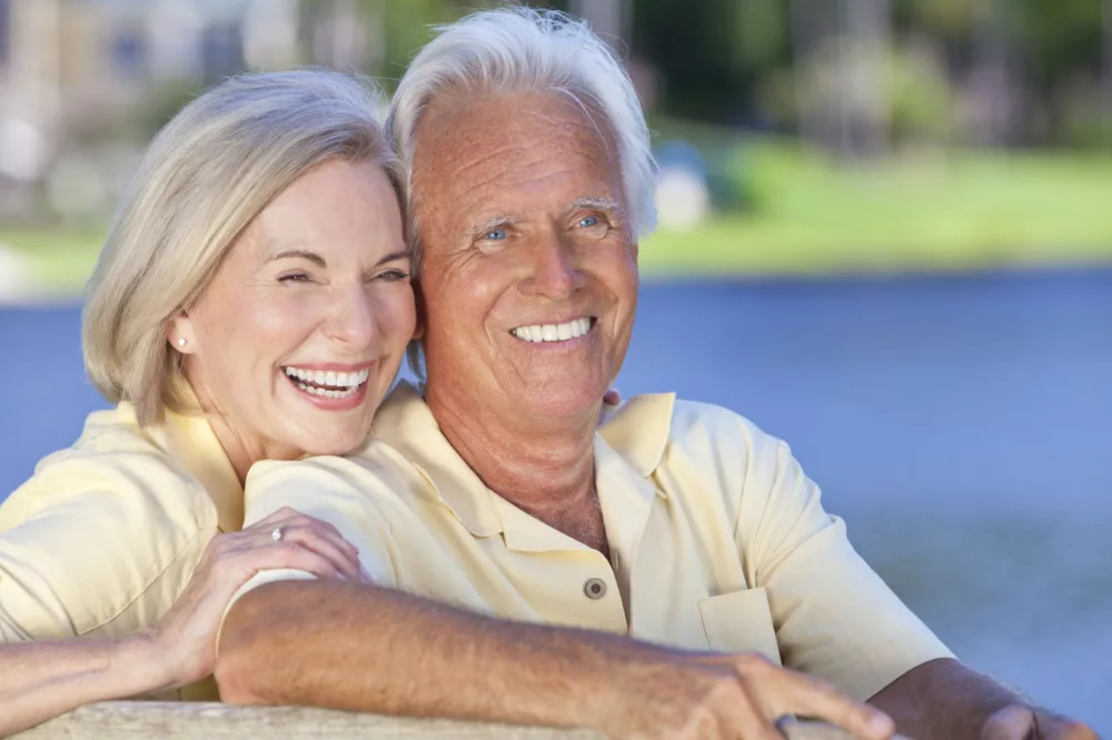 Senior couple grandparents by water - stock