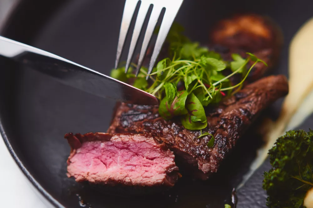 Beef tenderloin steak being cut in food plate from Gold Penfolds Dinner premium dining menu non-ccc influencer