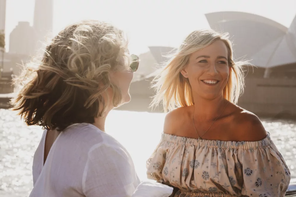 Two girls friends having drinks and enjoying views from open deck