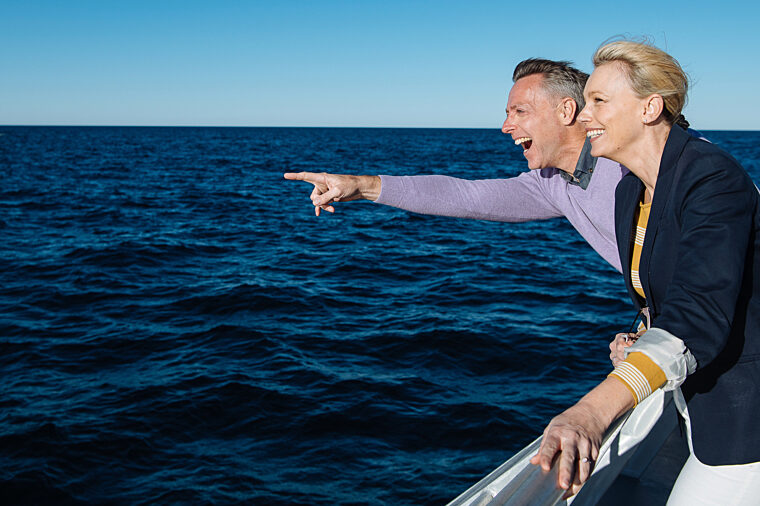 Couple spotting whales on open water sightseeing wildlife non-ccc dnsw