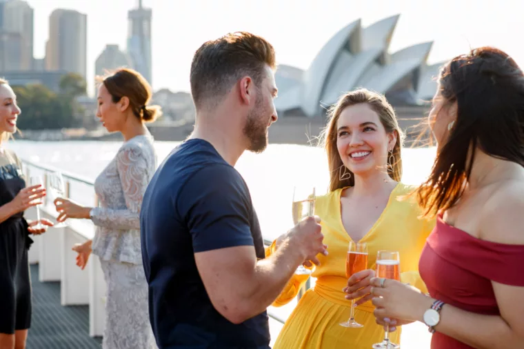 Group charter celebrating party corporate drinking champagne with Opera House in the background