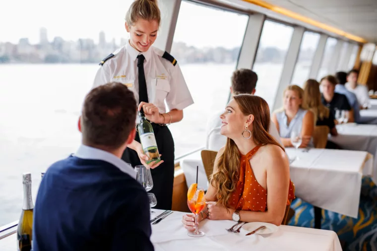 Waitress crew presenting Tyrrell's wines to couple having Top Deck Lunch and cocktails on Sky Deck
