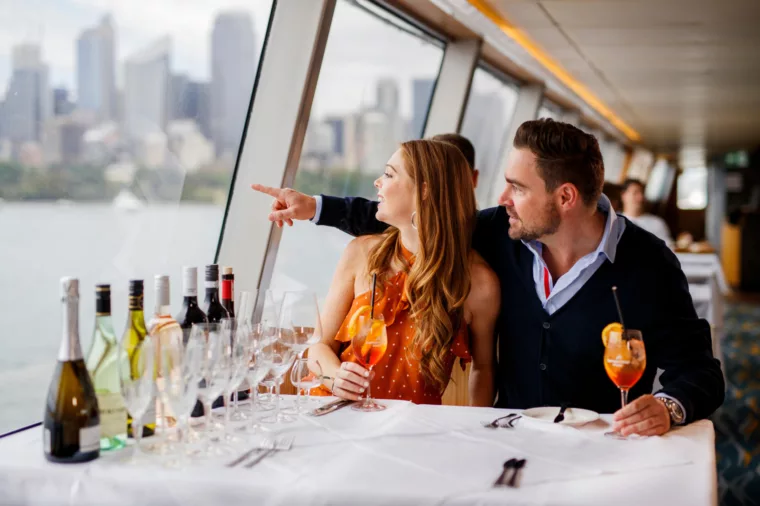 Couple having Top Deck Lunch pointing to sights and having a cocktail drink