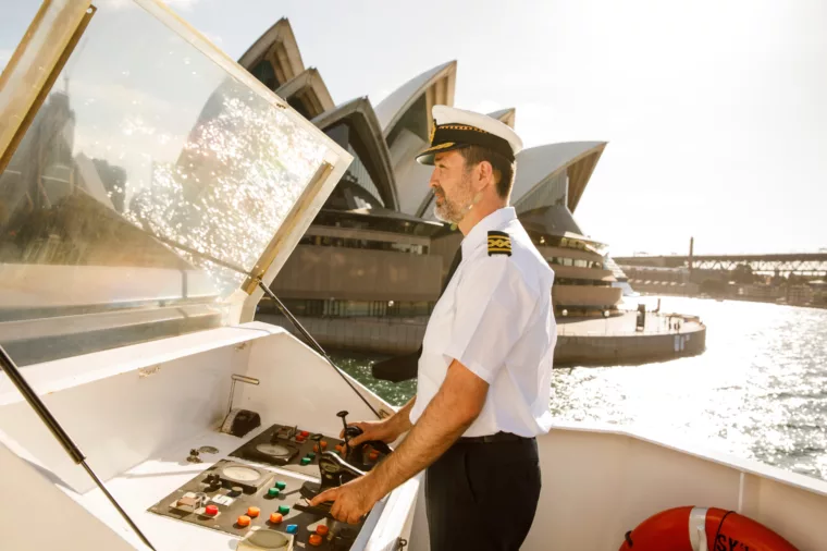 Captain driving Sydney 2000 boat past Opera House