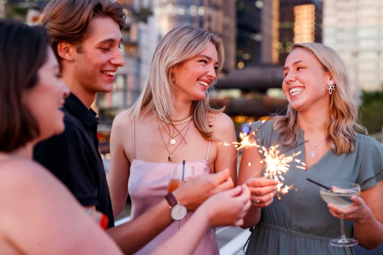 Groups of young friends celebrating birthday drink with Barangaroo in the background