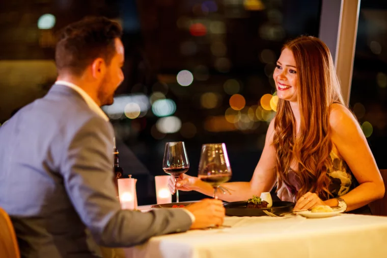 Couple having Gold Penfolds Dinner with wine glasses and dine table romance