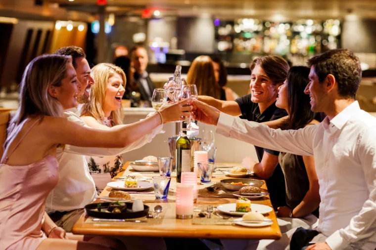 Group having dinner on Sky Deck cheers wine, dine and drinks
