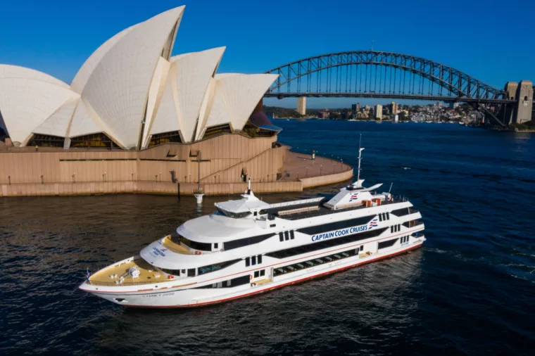 Sydney 2000 boat cruising past Opera House during the day Harbour Bridge in the background