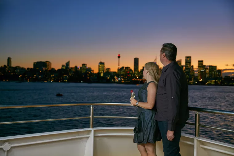 Valentines Day couple enjoying champagne and city skyline views at sunset