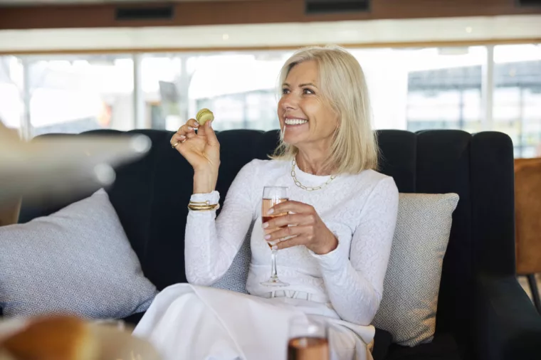 Lady enjoying High Tea at Sea sweet treats wine, BB