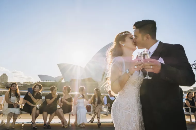Couple groom and bride kissing after wedding ceremony onboard Captain Cook 3 charter non-ccc