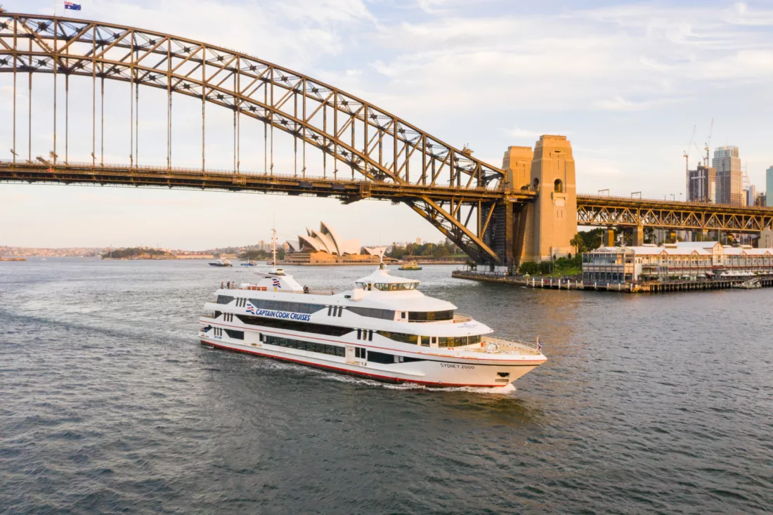 Sydney 2000 boat cruising past Harbour Bridge