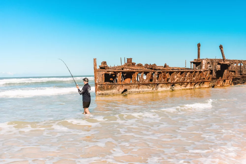 Man fishing at Maheno Shipwreck on K'gari (Fraser Island)