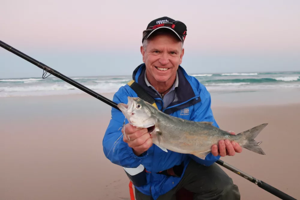 Man holding fish on beach, K'gari (Fraser Island)