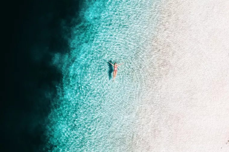 Aerial of girl swimming in Lake McKenzie, K'gari (Fraser Island)