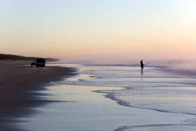 Man fishing along 75 Mile Beach at sunrise, K'gari (Fraser Island)