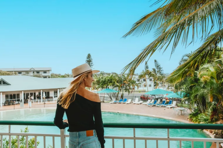 Girl on balcony overlooking pool at K'gari Beach Resort, K'gari Fraser Island