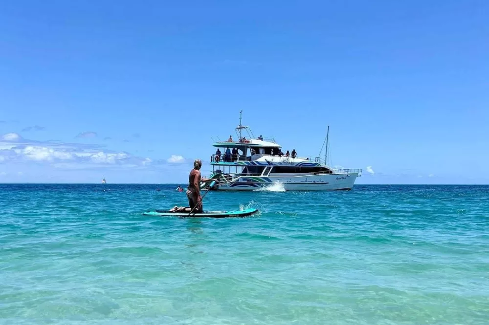 Stand-up-paddle-boarding through the crystal-clear waters off the west coast of K'gari Fraser Island.