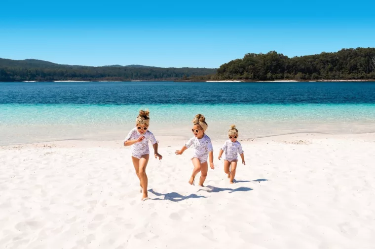 Three girls running on beach at Lake McKenzie