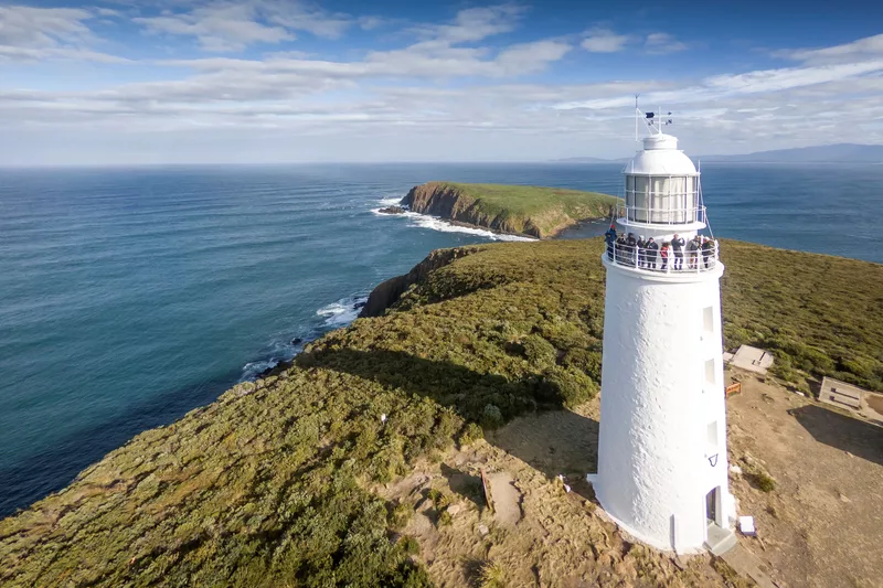 An aerial shot of Cape Bruny Lighthouse with the ocean in the background