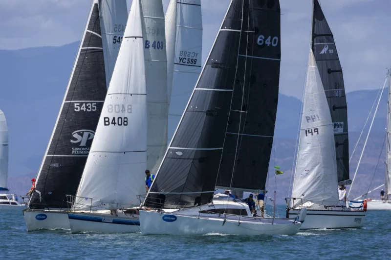 Yachts arranged along the coast, ready to start racing.