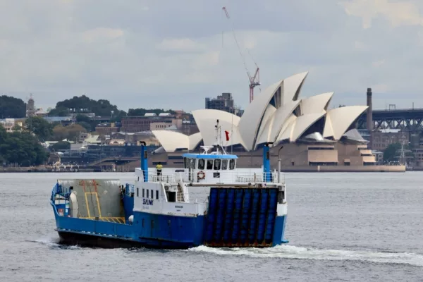 A white and blue ferry with Sydney's Opera House in the background