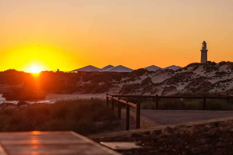 Sunrise over Pinky Beach on Rottnest Island with Bathurst Lighthouse and glamping tents in the background