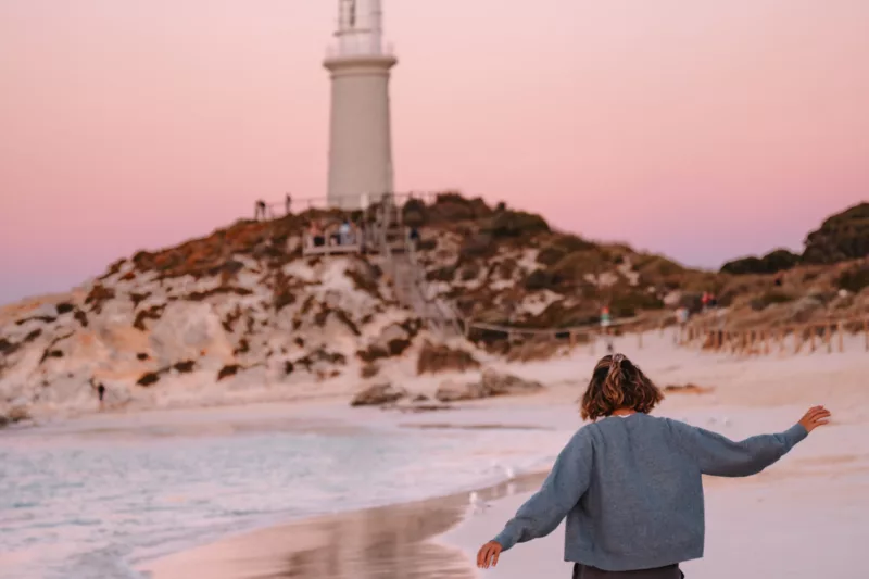 Person walking along Pinky Beach at Sunset