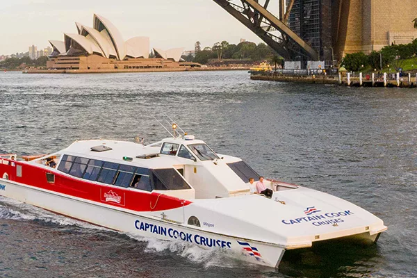 A white and red ferry against Sydney harbour