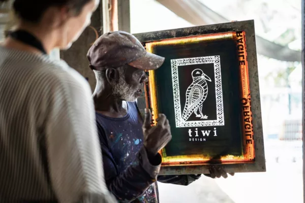 Tiwi artist showing artwork to travellers