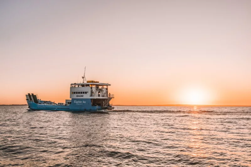 Ferry cruising in the water at sunset on K'gari