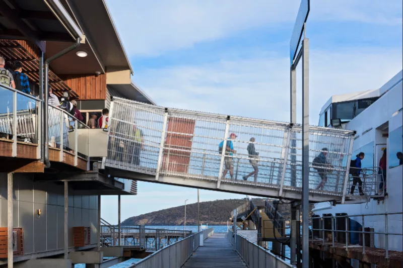 Persons boarding ferry via walkway