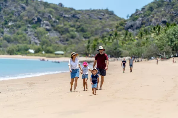 A family walks on a beach in Magnetic Island