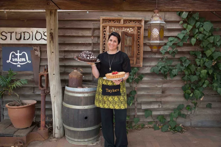 Lady holding cake outside Taylors in the Valley
